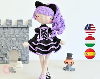 May include: A handmade crochet doll with a black dress, purple hair, and cat ears. The doll has a black and white color scheme, with a corset-style bodice and a ruffled skirt. The doll is standing in front of a gray stone castle.