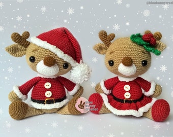 May include: Two crocheted reindeer wearing Santa Claus outfits. One reindeer is wearing a red hat with a white pom-pom and the other reindeer is wearing a green holly wreath with red berries.