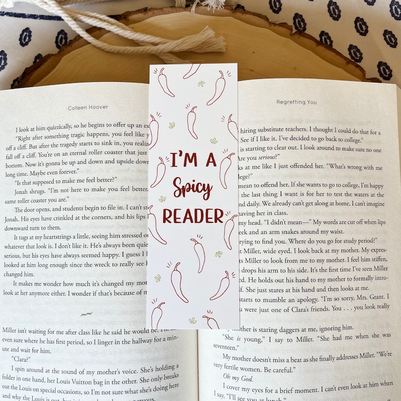 K&ouml;nnte beinhalten: Nahaufnahme eines Lesezeichens mit einem roten und wei&szlig;en Chili-Pfeffer-Design. Das Lesezeichen tr&auml;gt den Text "I'm a Spicy Reader" in einem roten Kasten.