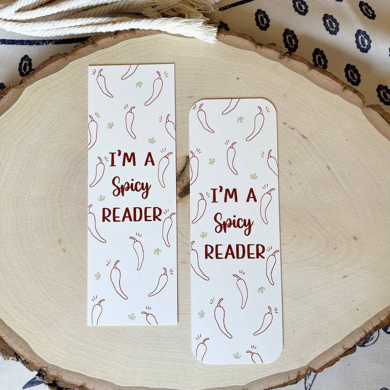 K&ouml;nnte beinhalten: Zwei wei&szlig;e Lesezeichen mit einem roten Chili-Muster und dem Text "I'm a Spicy Reader".