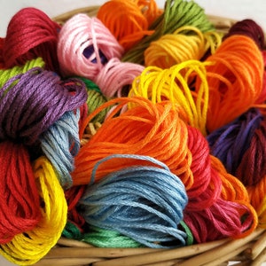 May include: A basket filled with colorful embroidery floss in shades of red, orange, yellow, green, blue, purple, and pink.