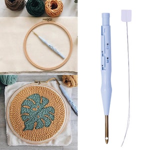 May include: A blue plastic punch needle tool with a gold needle and a white plastic needle threader. The tool has a handle with a sliding mechanism to adjust the needle depth. The tool is shown next to a wooden embroidery hoop with a green and yellow yarn design.