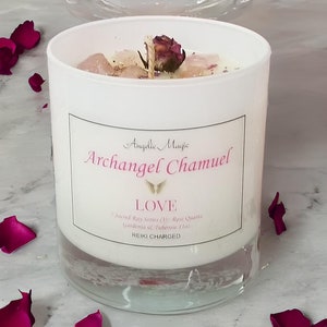 Puede incluir: Vela blanca con base de vidrio transparente, con una etiqueta que dice "Angelic Magic Archangel Chamuel LOVE Sacred Ray Series (3): Rose Quartz Gardenia & Tuberose  REIKI CHARGED". La vela está decorada con pétalos de rosa secos y cristales.