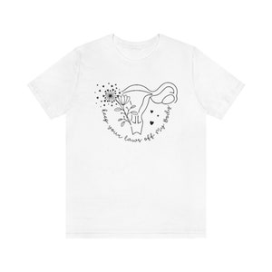 Peut inclure: T-shirt blanc avec un dessin au trait noir d'un ut&eacute;rus avec une fleur et des feuilles &agrave; l'int&eacute;rieur. Le texte "keep your laws off my body" est &eacute;crit en cercle autour de l'ut&eacute;rus.