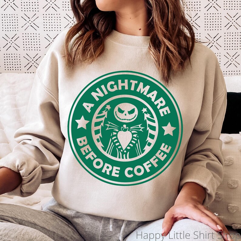 Pu&ograve; includere: Felpa beige con grafica verde. La grafica &egrave; una parodia del logo di una caffetteria, con Jack Skellington da The Nightmare Before Christmas, con la scritta "A Nightmare Before Coffee."