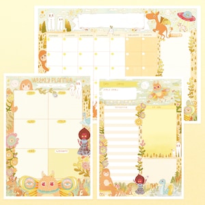 Puede incluir: Un conjunto de planificadores de papel ilustrados, caprichosos, con una combinación de colores amarillo y crema. El conjunto incluye un planificador semanal, un calendario mensual y un planificador diario, todos adornados con criaturas fantásticas y bordes florales. El texto incluye "WEEKLY PLANNER", "DAILY GOALS" y días de la semana.