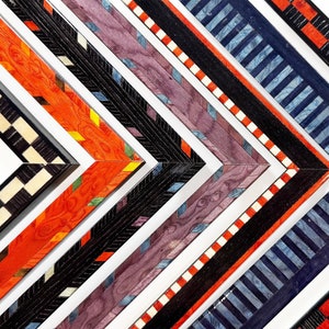 May include: Five different picture frames with decorative wood inlays. The frames are arranged in a diagonal pattern, with the top frame being the widest and the bottom frame being the narrowest. The frames are made of wood with different colors and patterns, including black, white, red, blue, and purple.