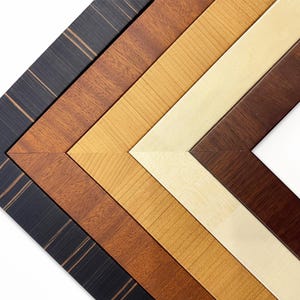 May include: Five different wood picture frames arranged in a corner pattern. The frames are in various shades of brown, black, and cream.