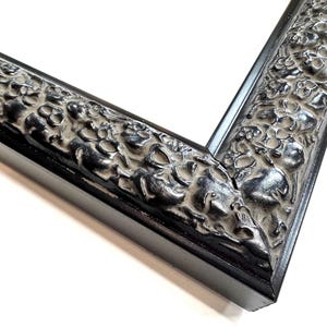 May include: Black picture frame with an ornate, textured design. The frame has a wide, flat profile and a smooth, black finish. Skulls Gothic Picture Frames Silver Black Eclectic Unique Photo Display Metallic Wood  Gift Wall Deco 4x6 5x7 8x10 11x14 16x20 18x24