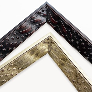 May include: Two L-shaped picture frame corners are displayed. The top frame is dark brown with a carved American flag pattern featuring stars and stripes. The bottom frame is a metallic gold color with a matching carved flag design.