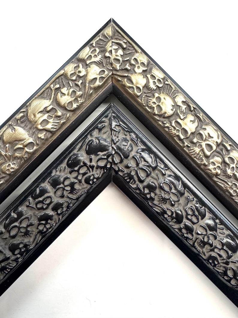 May include: Two picture frames with a skull design. The frame on the left is black with a silver skull design. The frame on the right is gold with a silver skull design. Skulls Gothic Picture Frames Silver Black Eclectic Unique Photo Display Metallic Wood Gift Wall Deco 4x6 5x7 8x10 11x14 16x20 18x24