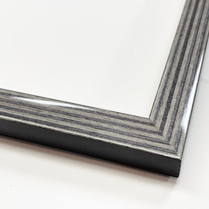 May include: Close-up of a corner of a black and gray wood picture frame with a glossy finish.