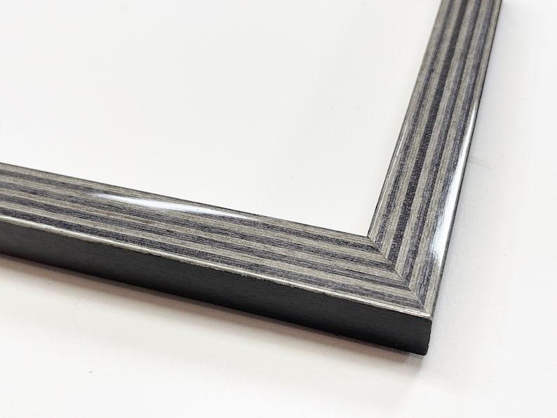May include: Close-up of a corner of a black and gray wood picture frame with a glossy finish.