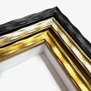 May include: Close-up of a corner of a picture frame with a black, gold, and silver finish. The frame has a textured, wavy design.