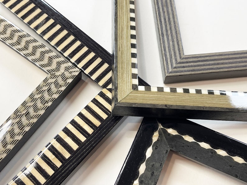 May include: Five different picture frames with black and white patterned borders. The frames are made of wood and have a variety of designs, including stripes, zigzags, and scallops.