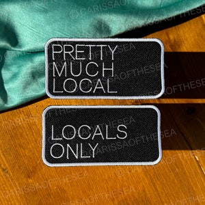 May include: Two black and white embroidered patches with white stitching. The top patch reads "Pretty Much Local" and the bottom patch reads "Locals Only".