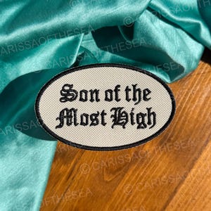 May include: White oval patch with black embroidered text that reads "Son of the Most High".