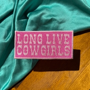 May include: Pink fabric patch with white embroidered text that reads "Long Live Cowgirls".