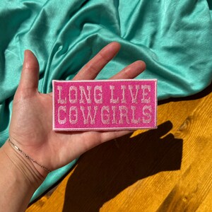 May include: Pink fabric patch with white embroidered text that reads "Long Live Cowgirls".