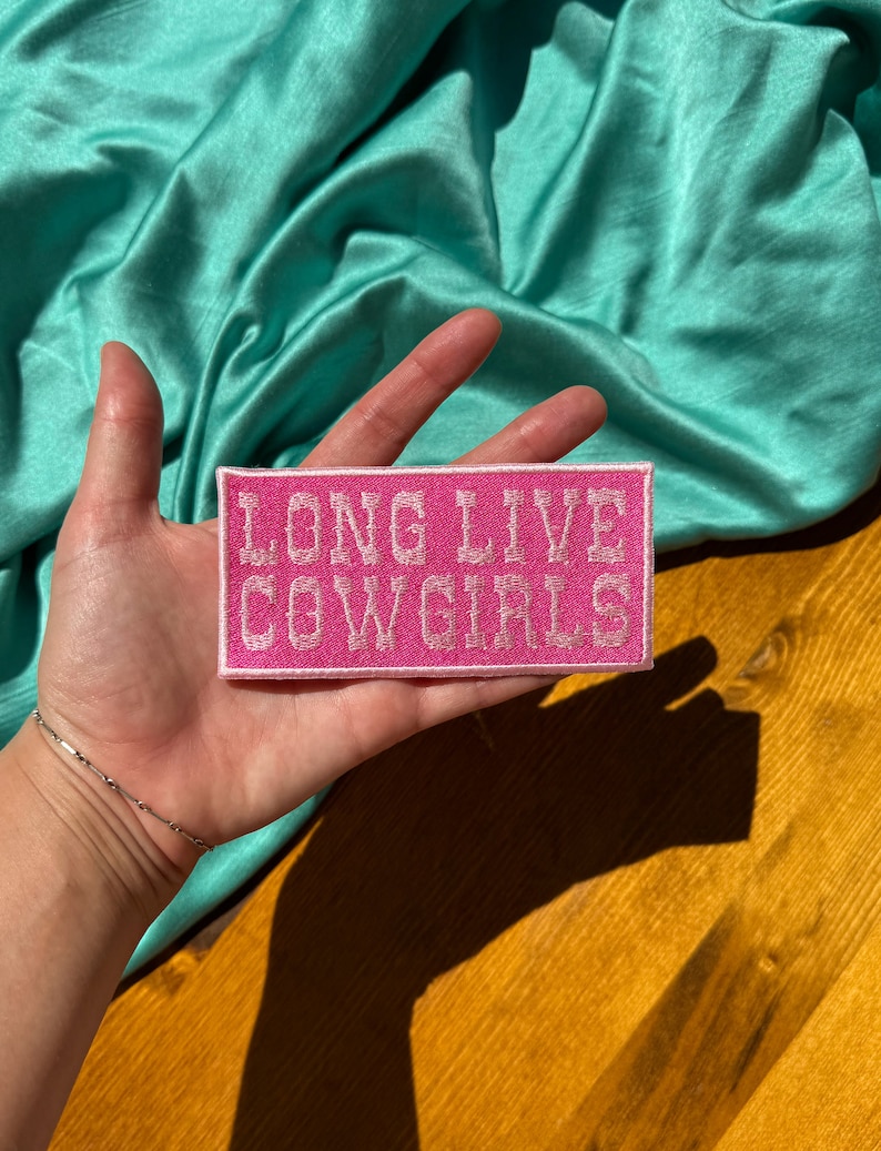 May include: Pink fabric patch with white embroidered text that reads "Long Live Cowgirls".