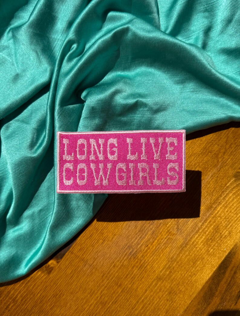 May include: Pink embroidered patch with white stitching that reads "Long Live Cowgirls".