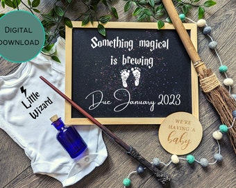May include: A baby announcement with a wizard theme. Includes a chalkboard with the text "Something magical is brewing" and "Due January 2023", a baby onesie with "Little Wizard" text, a wand, and a broom.