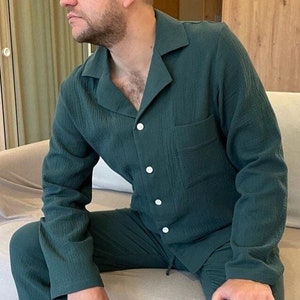 K&ouml;nnte beinhalten: Eine Person tr&auml;gt einen dunkelgr&uuml;nen Schlafanzug mit einem Hemd mit Kragen und einer langen Hose.
