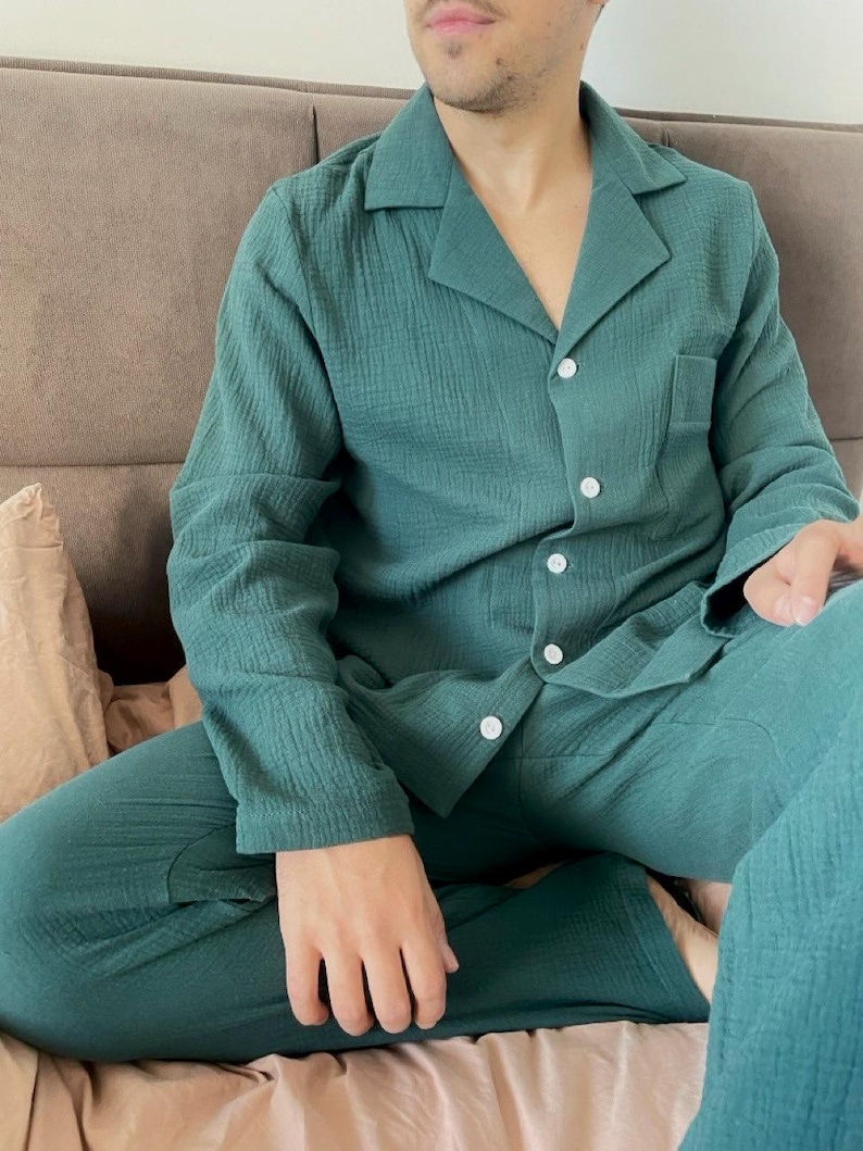 K&ouml;nnte beinhalten: Ein gr&uuml;ner lang&auml;rmliger Schlafanzug mit Oberteil und Hose im gleichen Design. Das Oberteil hat einen Kragen und einen Knopfverschluss. Der Stoff hat eine strukturierte Waffelstruktur.