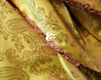 Könnte beinhalten: Nahaufnahme eines goldenen Stoffes mit Paisley-Muster. Der Stoff hat einen braunen Fransen entlang der Kante. Der Stoff ist mit "LAVAILLER & BOULGARA" beschriftet.