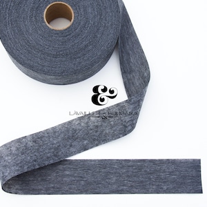 May include: A roll of dark gray fusible interfacing fabric. The interfacing is a woven fabric that is used to stiffen and stabilize fabrics.
