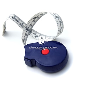 May include: A blue retractable tape measure with a white tape and black markings. The tape measure has a red button and the text "LAVAILLER & BOUGARA" printed on the side.
