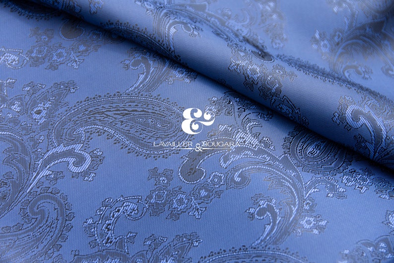 May include: Blue paisley patterned fabric with a black and white logo that reads "LAVALIER & BOUGAR" in the center.