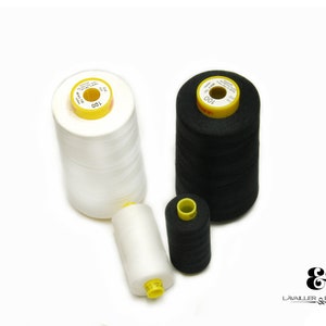 May include: Two spools of thread, one white and one black, with yellow labels that say "100".