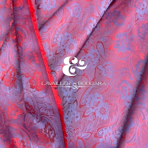 May include: A close-up of a purple and red fabric with a floral pattern. The fabric has a red border and the text "LAVAILLER & BOUCARA" is visible in the center.
