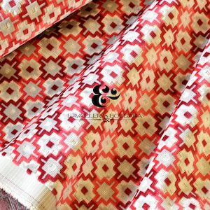 May include: Close-up of a folded fabric with a geometric pattern. The design features red, white, and gray diamond shapes. The fabric has a soft texture and is likely used for upholstery or home decor. The brand name "LAVAILLER & BOUGARA" is visible.