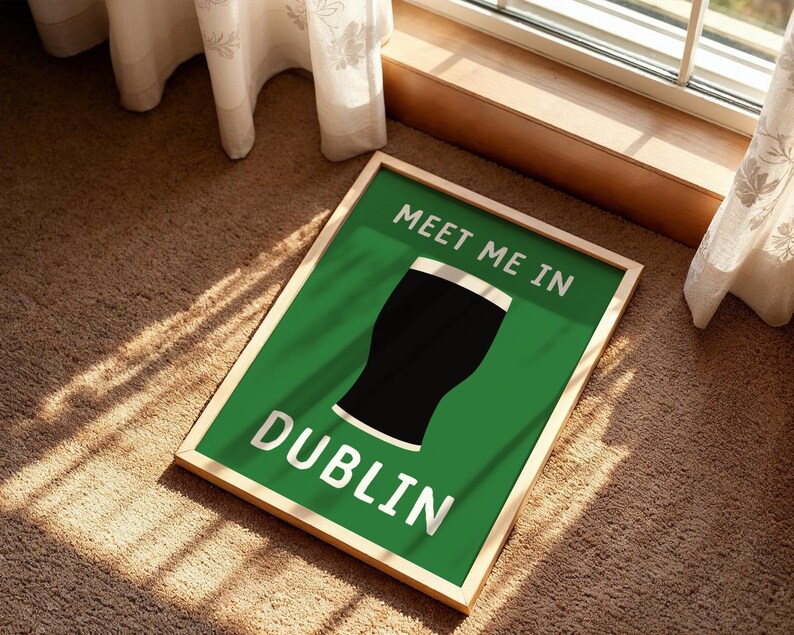 May include: A framed green sign with the words "MEET ME IN DUBLIN" in white lettering. A black pint of stout is in the center of the sign. The frame is a light wood color. The sign is on a brown carpet.