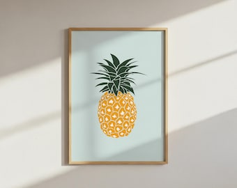 May include: A framed art print featuring a stylized pineapple illustration. The pineapple is yellow with a textured pattern, topped with dark green leaves. The background is a light blue, and the frame is a natural wood color.
