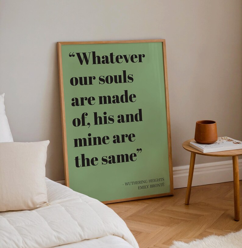 Op de afbeelding: Een rechthoekige ingelijste wandprint met een saliegroene achtergrond en zwarte schreefletters met de tekst "Whatever our souls are made of, his and mine are the same", gevolgd door "WUTHERING HEIGHTS EMILY BRONT&Euml;" in een kleiner lettertype.