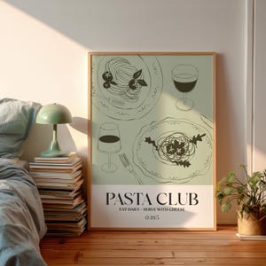 K&ouml;nnte beinhalten: Ein gerahmtes Poster mit hellgr&uuml;nem Hintergrund zeigt Strichzeichnungen von Pastagerichten und Weingl&auml;sern. Die Worte "PASTA CLUB" sind in fetter, schwarzer Schrift gedruckt, darunter der Text "EAT DAILY - SERVE WITH CHEESE". Die Nummer "0385" befindet sich unten.