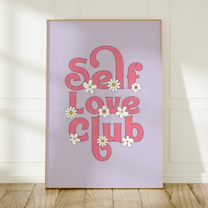May include: A rectangular wall art print featuring a light purple background with the pink text Self Love Club in a bold, rounded font. The design is decorated with several small white daisies with yellow centres scattered around the letters.