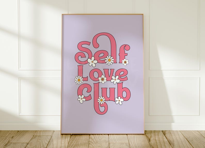 May include: A rectangular wall art print featuring a light purple background with the pink text Self Love Club in a bold, rounded font. The design is decorated with several small white daisies with yellow centres scattered around the letters.
