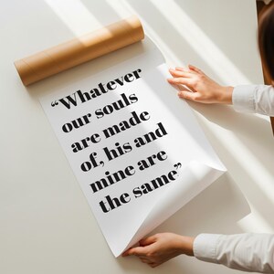Op de afbeelding: Een witte poster met de zwart gedrukte tekst "Whatever our souls are made of, his and mine are the same", gedeeltelijk uitgerold uit een cilindrische bruine kartonnen verzendkoker, met een duidelijk, vetgedrukt schreeflettertype.