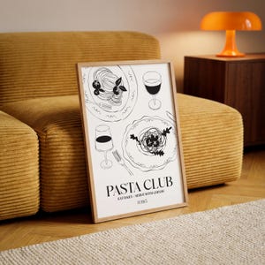 K&ouml;nnte beinhalten: Ein gerahmter Kunstdruck mit einer minimalistischen Schwarz-Wei&szlig;-Illustration von Pastagerichten und Weingl&auml;sern. Der Text "PASTA CLUB" ist unter den Illustrationen abgebildet, zusammen mit dem Slogan "EAT DAILY - SERVE WITH CHEESE" und der Nummer "0385". Der Rahmen ist aus hellem Holz.