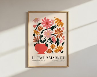 Puede incluir: Una impresión artística enmarcada que presenta un colorido arreglo floral en un jarrón rojo. Las flores son en tonos de rosa, naranja y amarillo, con tallos y hojas verdes. Las palabras "FLOWER MARKET" están impresas debajo del jarrón.