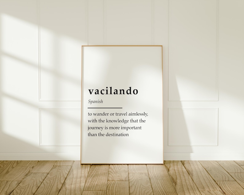 Puede incluir: Una impresi&oacute;n enmarcada blanca con la palabra espa&ntilde;ola "vacilando" y su definici&oacute;n: "vagar o viajar sin rumbo, con el conocimiento de que el viaje es m&aacute;s importante que el destino."