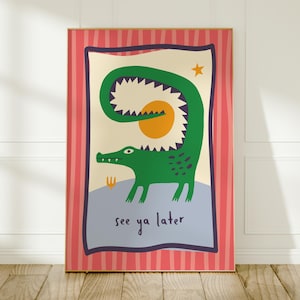 Pu&ograve; includere: Una stampa artistica rettangolare da parete raffigurante un coccodrillo verde con la coda curva, un sole giallo e una piccola stella su sfondo crema. Il testo see ya later &egrave; stampato in nero. Il bordo &egrave; rosa con strisce verticali rosse.