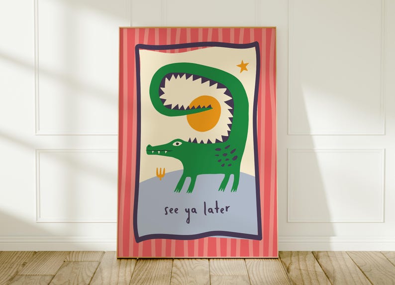 Pu&ograve; includere: Una stampa artistica rettangolare da parete raffigurante un coccodrillo verde con la coda curva, un sole giallo e una piccola stella su sfondo crema. Il testo see ya later &egrave; stampato in nero. Il bordo &egrave; rosa con strisce verticali rosse.