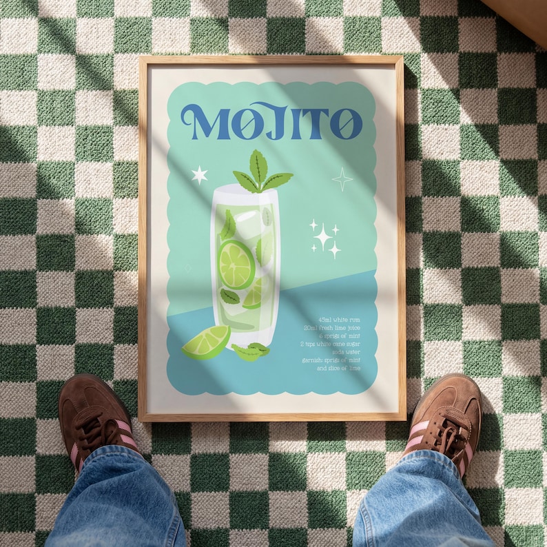 May include: A framed print featuring a Mojito cocktail illustration. The artwork showcases a tall glass filled with ice, lime slices, and mint, with the word "Mojito" in stylized blue lettering. The background is a light teal color.