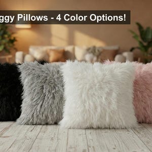 May include: Four shaggy pillows in black, gray, white, and pink are displayed on a wooden floor. The pillows have a fluffy, textured appearance. The text "Shaggy Pillows - 4 Color Options!" is displayed above the pillows.