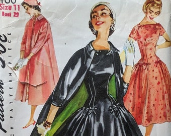 May include: Vintage Simplicity sewing pattern 1460 for a dress with a 50c price tag. The pattern shows three women wearing different dresses. The woman in the center is wearing a black dress with a green jacket. The woman on the left is wearing a pink dress with a white jacket. The woman on the right is wearing a pink dress with white polka dots.
